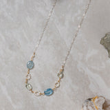 Necklace with aquamarine blue and freshwater pearl beads on a marble surface
