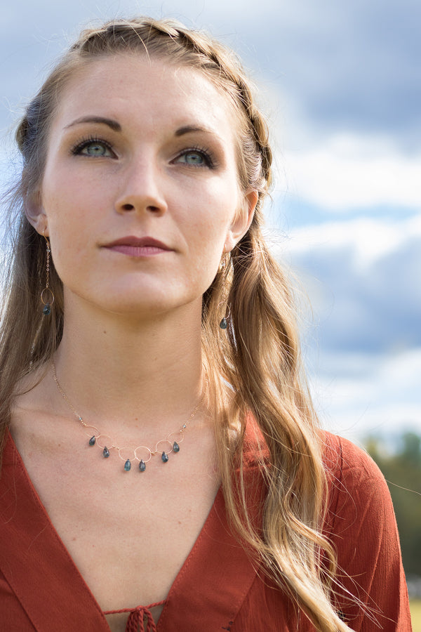 Gold necklace with delicate links and drops of kyanite on a model