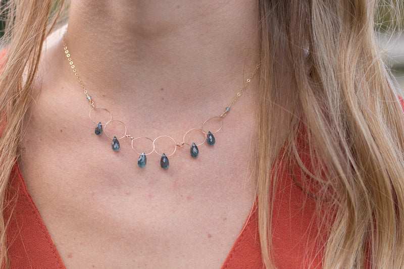 Gold necklace with delicate links and drops of kyanite on a model